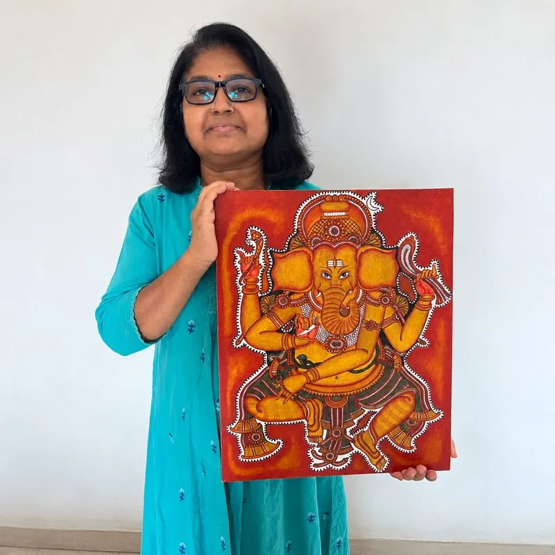 Nagulesh Ravindran holding her Kerala mural Ganesha painting